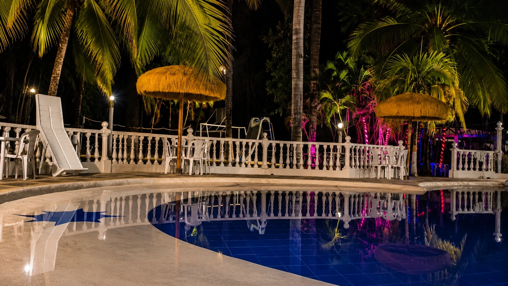 Sombrilla tipo kiosco y piscina iluminada del hotel